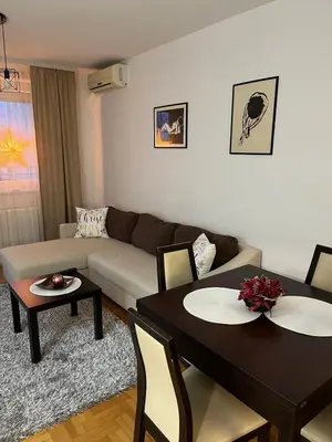 a living room with two tables and a couch at Apartman KIKA in Banja Luka