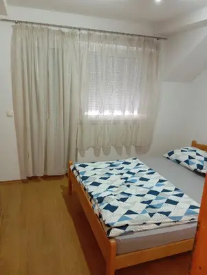a bedroom with a bed in front of a window at Guest house A S S in Sanski most