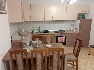 a kitchen with a table and chairs and a stove at Guest house A S S in Sanski most