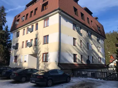 a building with cars parked in front of it at Sindbad Vlašić in Vlasic