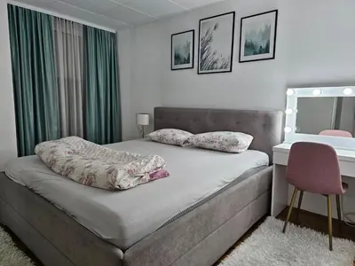 a bedroom with a bed and a desk and a mirror at Apartman Nova Varos in Banja Luka