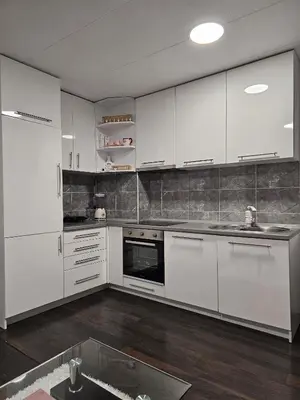 a white kitchen with white cabinets and a sink at Apartman Nova Varos in Banja Luka