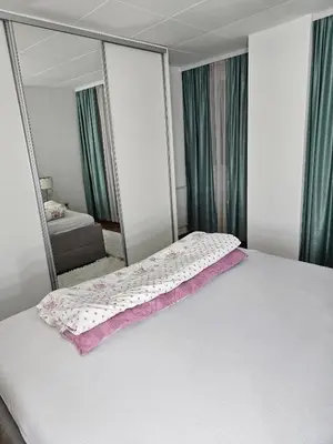 a bedroom with a white bed and a mirror at Apartman Nova Varos in Banja Luka