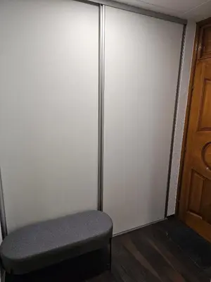 an empty closet with a bench and a door at Apartman Nova Varos in Banja Luka