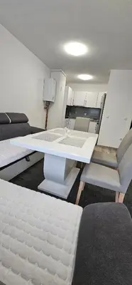 a room with a bed and a table and chairs at Apartman Mima in Sanski most
