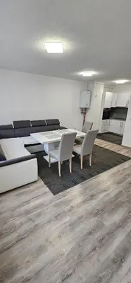 a living room with a table and chairs and a couch at Apartman Mima in Sanski most