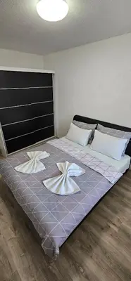 a large bed with two flowers on it in a room at Apartman Mima in Sanski most
