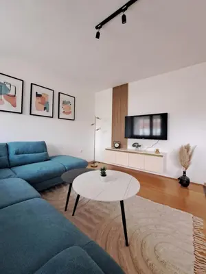 a living room with a blue couch and a table at Apartman Mika in Kupres