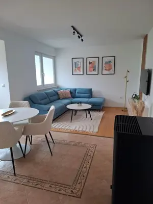 a living room with a blue couch and a table at Apartman Mika in Kupres