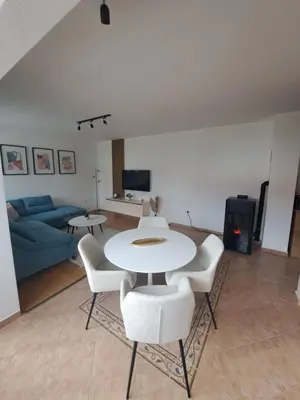 a living room with a table and chairs and a couch at Apartman Mika in Kupres