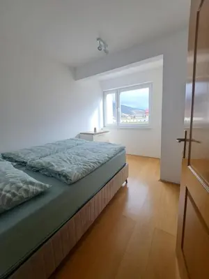 a white bedroom with a bed and a window at Apartman Mika in Kupres
