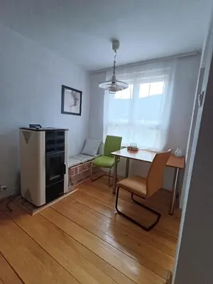 a living room with a table and green chairs at Apartman Vuk in Drvar