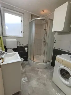 a bathroom with a shower and a toilet and a sink at Apartman Vuk in Drvar