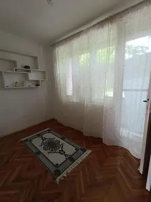 a room with a window and a rug on a wooden floor at Apartman Vuk in Drvar