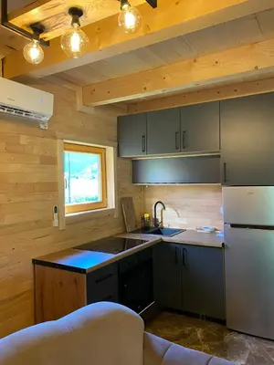 a kitchen with a refrigerator and a sink in a room at Vikendica ANA in Šipovo