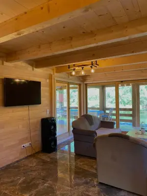 a living room with a flat screen tv and a couch at Vikendica ANA in Šipovo