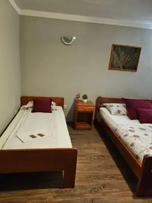 a bedroom with two beds and a night stand with at Genex-M in Bugojno