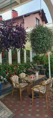 a wooden table and chairs with a table and flowers at Genex-M in Bugojno