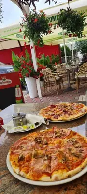 two pizzas sitting on top of a table at Genex-M in Bugojno