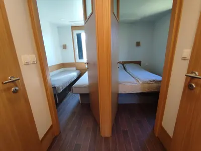 a small room with two beds and a door to a bedroom at Ćuranov rep in Mrkonjić Grad