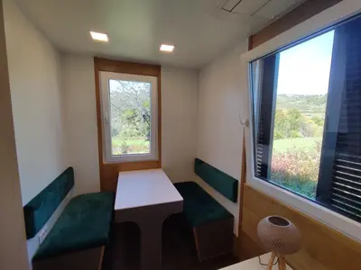 a small room with two chairs and a table and a window at Ćuranov rep in Mrkonjić Grad