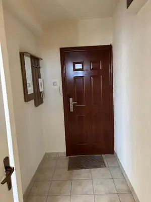 a wooden door in a hallway with a tile floor at Apartment Banja Luka in Banja Luka
