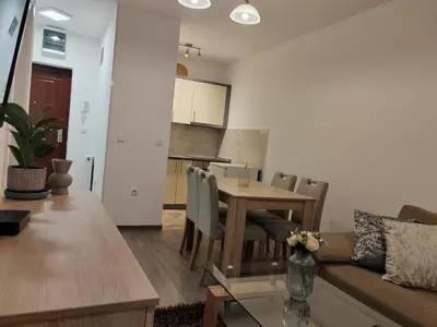 a living room and kitchen with a table and a couch at Stan na dan Modriča in Modriča