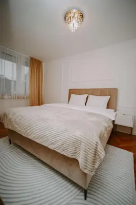 a bedroom with a large bed and a chandelier at Gold Luxury Apartment in Bosanska Gradiška