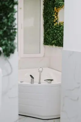 a white bathroom with a sink and a mirror at Gold Luxury Apartment in Bosanska Gradiška