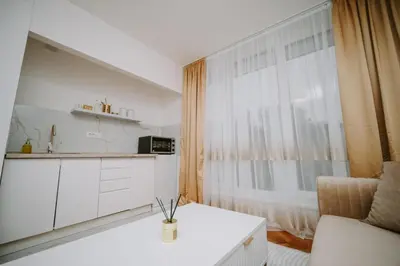 a small white kitchen with a table and a window at Gold Luxury Apartment in Bosanska Gradiška