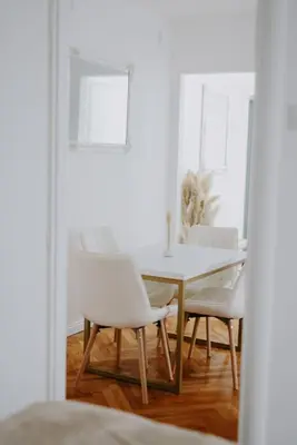 a dining room with a white table and chairs at Gold Luxury Apartment in Bosanska Gradiška