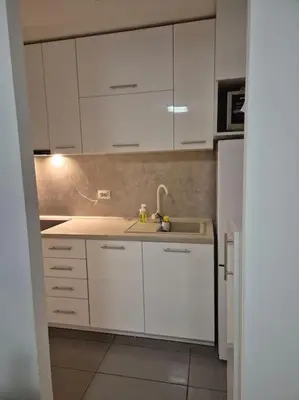 a kitchen with white cabinets and a sink at Studio Apartment Borik 19 in Banja Luka