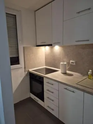 a kitchen with white cabinets and a sink at Studio Apartment Borik 19 in Banja Luka