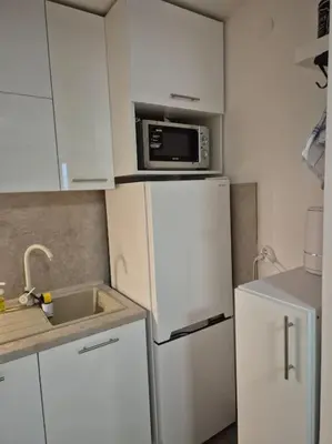 a kitchen with a white refrigerator and a microwave at Studio Apartment Borik 19 in Banja Luka