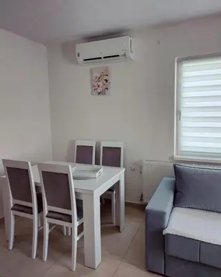 a living room with a table and chairs and a couch at Stan na dan Gabriella in Prijedor