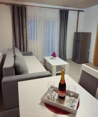 a living room with a bottle of wine and glasses on a table at Stan na dan Gabriella in Prijedor