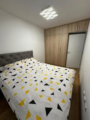 a bedroom with a bed with a yellow and white quilt at Apartman Mia in Doboj