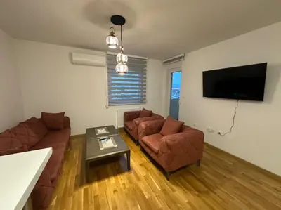 a living room with two couches and a flat screen tv at Apartman Mia in Doboj