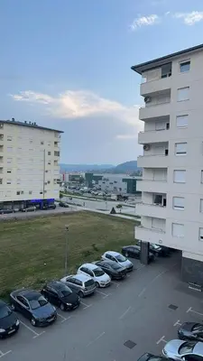 a group of cars parked in a parking lot next to a building at Apartman Mia in Doboj