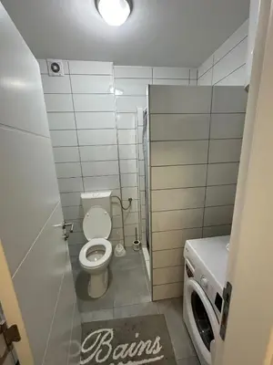 a bathroom with a toilet and a washing machine at Apartman Mia in Doboj