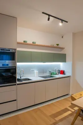 a kitchen with white cabinets and a sink at Apartment OMEGA in Banja Luka
