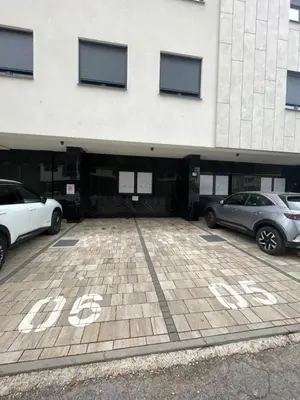 two cars parked in a parking lot in front of a building at Apartment OMEGA in Banja Luka