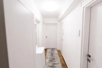 a hallway with white walls and a white sink and mirror at Tanja in Banja Luka