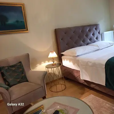 a bedroom with a bed and a chair and a table at Lux Palata in Banja Luka