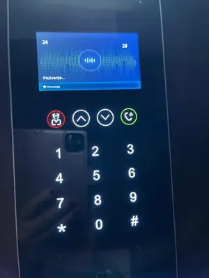 a person is holding a cell phone with a remote control at Lux Palata in Banja Luka