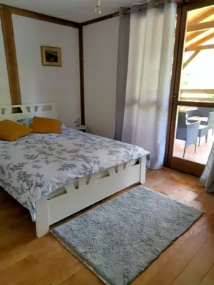 a bedroom with a bed with a rug and a window at Vikendica Čardak in Srebrenik