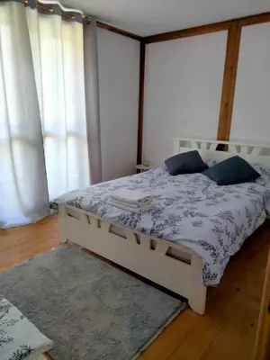 a bedroom with a white bed with blue pillows at Vikendica Čardak in Srebrenik