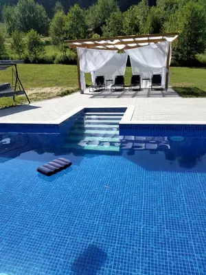 a pool with a gazebo and a swimming pool at Vikendica Čardak in Srebrenik
