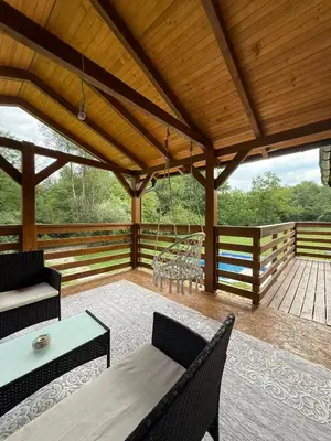 a screened in porch with a table and chairs at Vikendica Čardak in Srebrenik