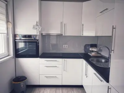 a white kitchen with white cabinets and a sink at Apartman Luxe in Livno